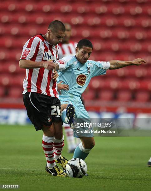Ramone Rose of Northampton Town challenges for the ball with Adam Lallana of Southampton during the Carling Cup Round One Match between Southampton...