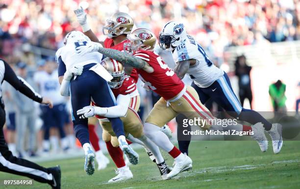 Reuben Foster and Cassius Marsh of the San Francisco 49ers pressure Marcus Mariota of the Tennessee Titans during the game at Levi's Stadium on...