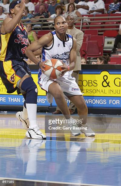 Elaine Powell of the Orlando Miracle drives around Alicia Thompson of the Indiana Fever in the game on June 11, 2002 at TD Waterhouse Centre in...