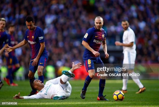Barcelona's Spanish midfielder Andres Iniesta eyes the ball next to Real Madrid's Brazilian midfielder Casemiro during the Spanish League "Clasico"...