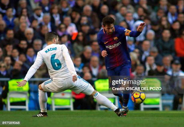 Real Madrid's Spanish defender Nacho Fernandez vies with Barcelona's Argentinian forward Lionel Messi during the Spanish League "Clasico" football...