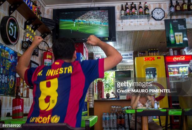Brazilian fan of Spain's Barcelona celebrates the first goal against Spain's Real Madrid at a bar in Copacabana neighborhood in Rio de Janeiro,...