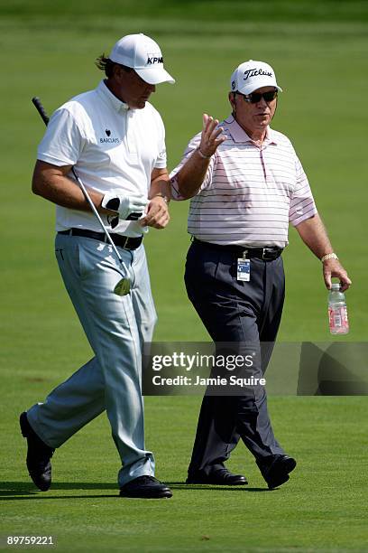 Phil Mickelson and swing coach Butch Harmon talk during the third preview day of the 91st PGA Championship at Hazeltine National Golf Club on August...