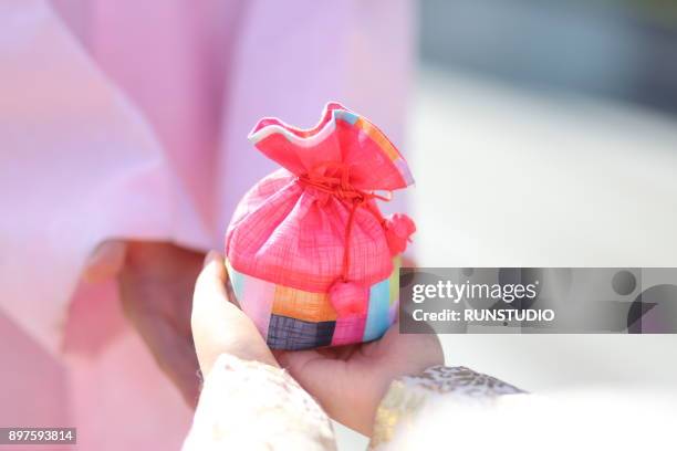 cropped image of couple wearing korean traditional clothes with lucky bag - personal perspective festival stock pictures, royalty-free photos & images