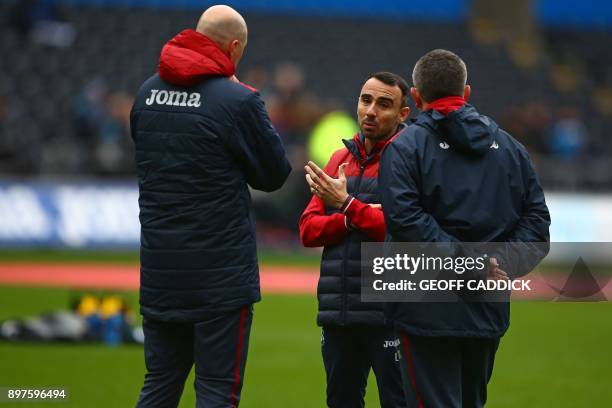 Swansea City's English midfielder Leon Britton , interim manager speaks to his assistants on the pitch ahead of the English Premier League football...