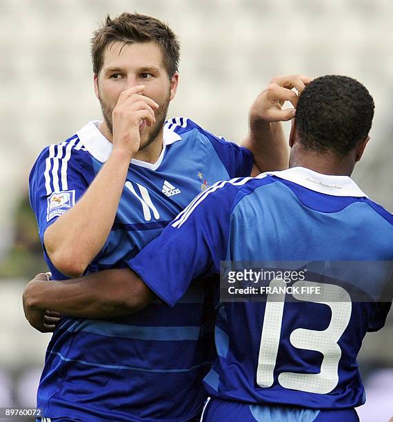 French forward Andre-Pierre Gignac is congratuled by teammate Patrice Evra after scoring a goal during the World Cup 2010 qualifying football match...