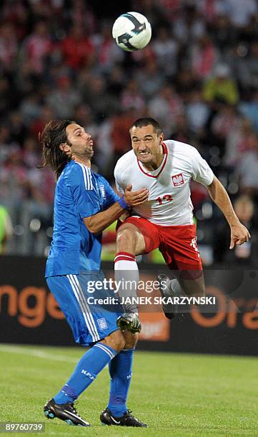 Marcin Wasilewski of Poland jumps for a header with Greece's Georgios Samaras during their international friendly football match on August 12, 2009...