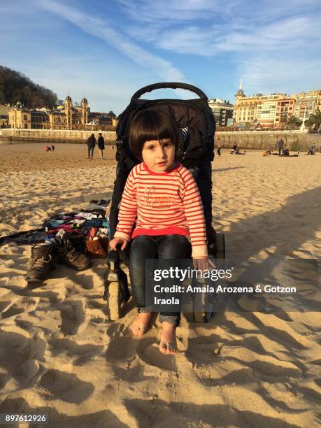 little girl in la concha beach at sunset. donostia-san sebastian, basque country - playa de la concha fotografías e imágenes de stock