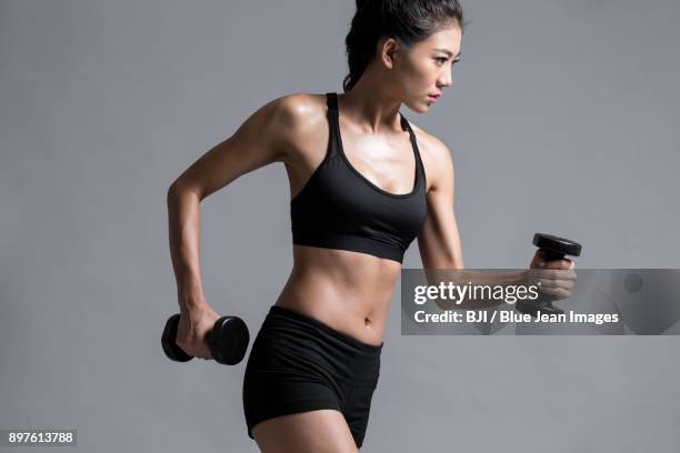 young female athlete exercising - asian female bodybuilder stock-fotos und bilder