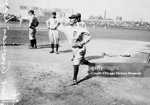 Informal full-length portrait of Hall of Fame baseball player Ty Cobb of the American League's Detroit Tigers, throwing a baseball, standing on the...
