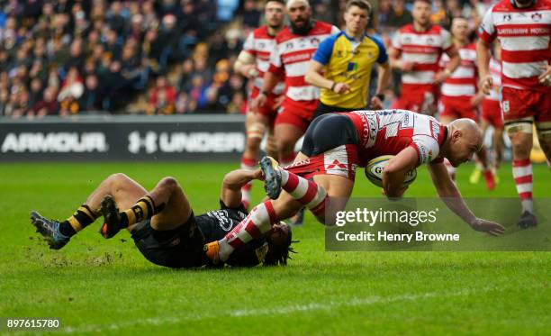 Willi Heinz of Gloucester scores their first try despite the efforts of Kyle Eastmond of Wasps during the Aviva Premiership match between Wasps and...