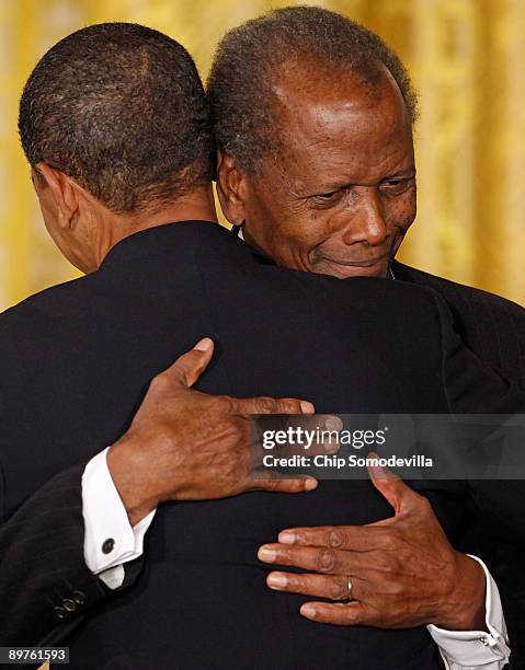 President Barack Obama embraces Academy Award-winning actor Sidney Poitier after presenting him with the Medal of Freedom during a ceremony in the...