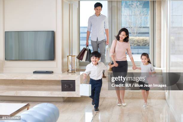 young family coming back from shopping - tv shop window stock pictures, royalty-free photos & images