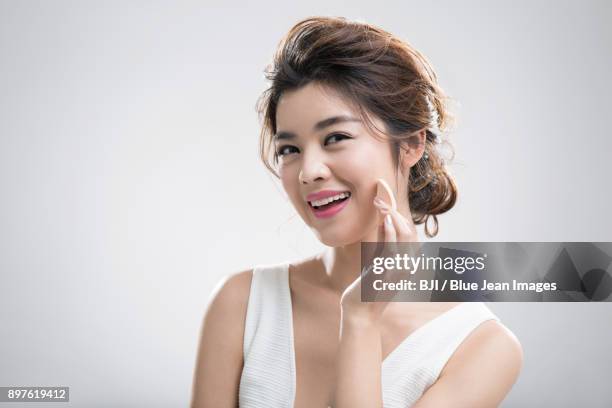 young woman applying facial powder - powder puff stock pictures, royalty-free photos & images