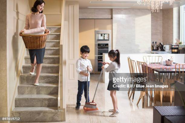 happy family doing laundry and sweeping at home - sweeping floor stock pictures, royalty-free photos & images
