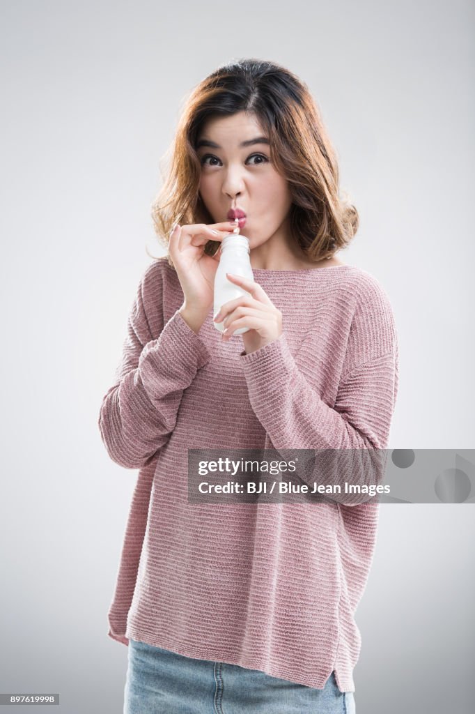 Beautiful young woman drinking milk