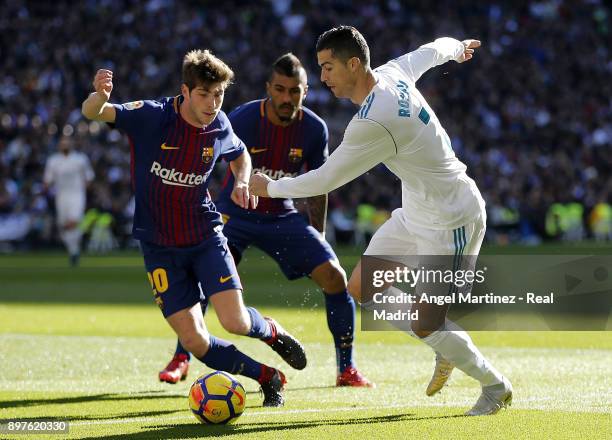 Cristiano Ronaldo of Real Madrid competes for the ball with Sergi Roberto of FC Barcelona during the La Liga match between Real Madrid and Barcelona...