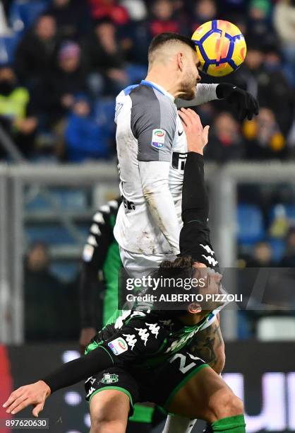 Inter Milan's Argentinian forward Mauro Icardi fights for the ball with Sassuolo's Italian defender Edoardo Goldaniga during the Italian Serie A...