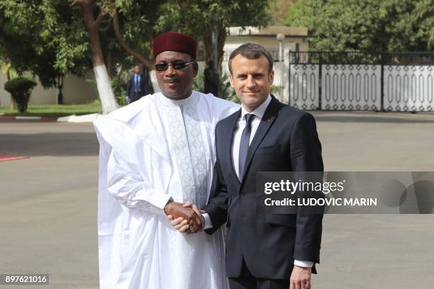 Niger president Mahamadou Issoufou shakes hands with French president Emmanuel Macron during a military welcome ceremony at the Presidential palace...