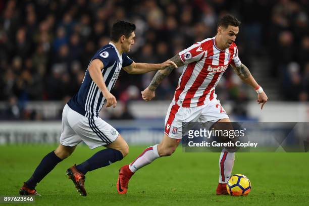 Geoff Cameron of Stoke City attempts to get away from Gareth Barry of West Bromwich Albion during the Premier League match between Stoke City and...