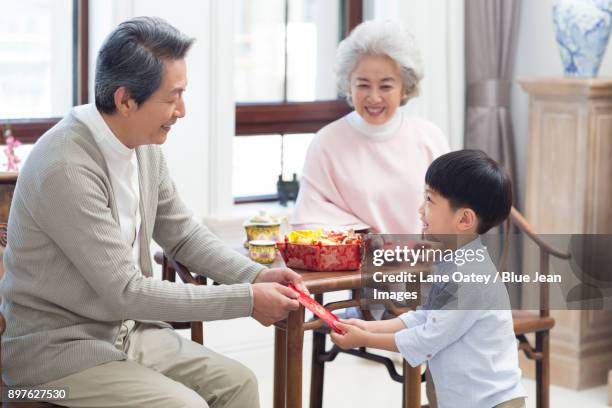 grandparents giving red pockets to grandson - lunar new year cup 2017 stock-fotos und bilder