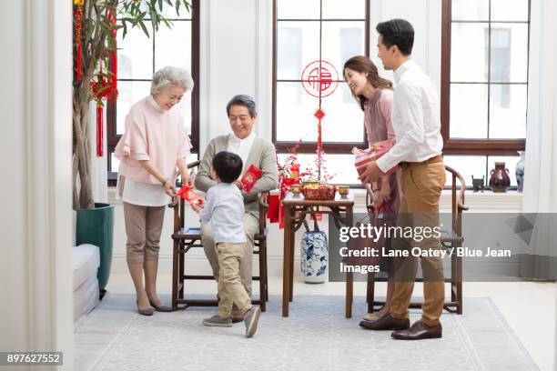 family visiting with gifts during chinese new year - 65 year old asian women stockfoto's en -beelden