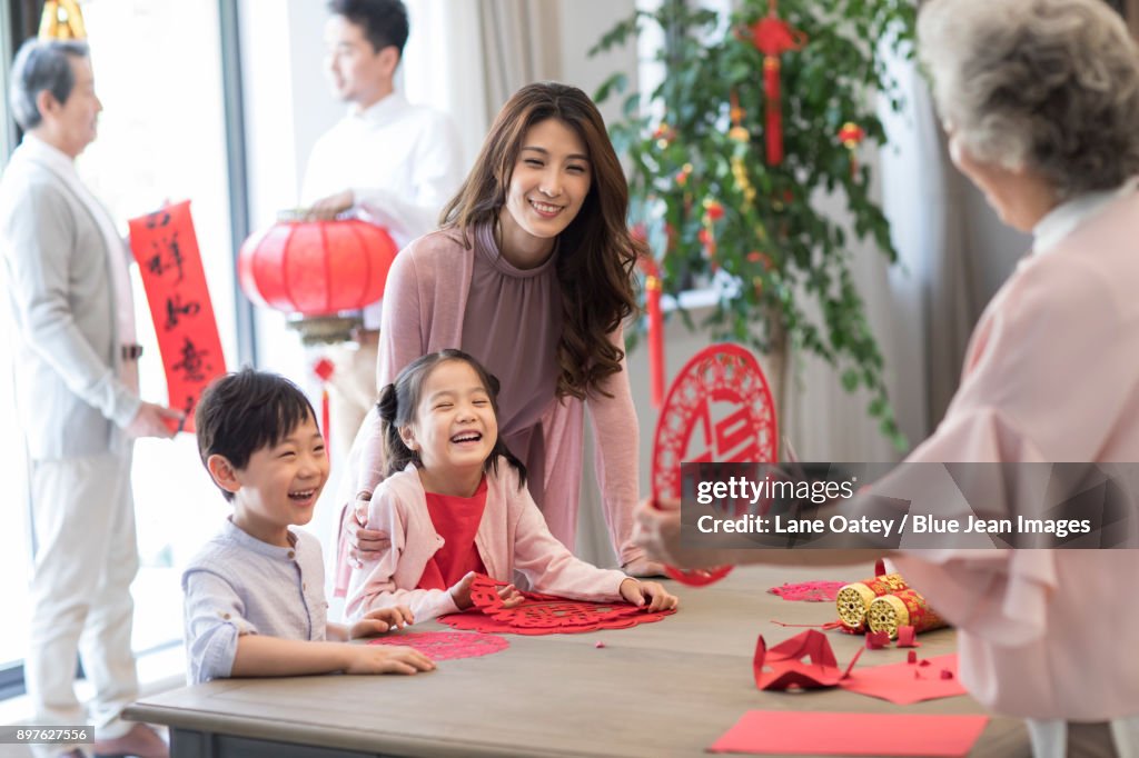 Grandchildren and grandmother with Chinese New Year paper-cut