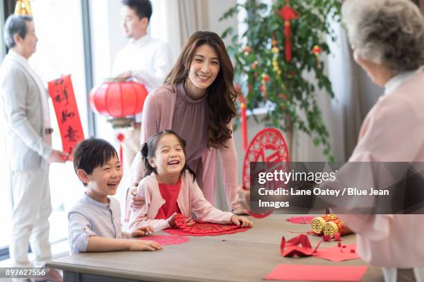 grandchildren and grandmother with chinese new year paper-cut - chinese prepare for lunar new year stock-fotos und bilder