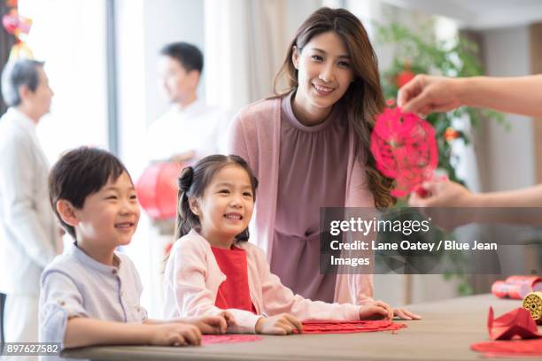 grandchildren and grandmother with chinese new year paper-cut - chinese prepare for lunar new year stock pictures, royalty-free photos & images