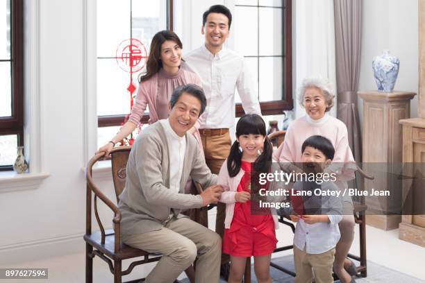 happy family celebrating chinese new year - 30 year old portrait in house stock-fotos und bilder