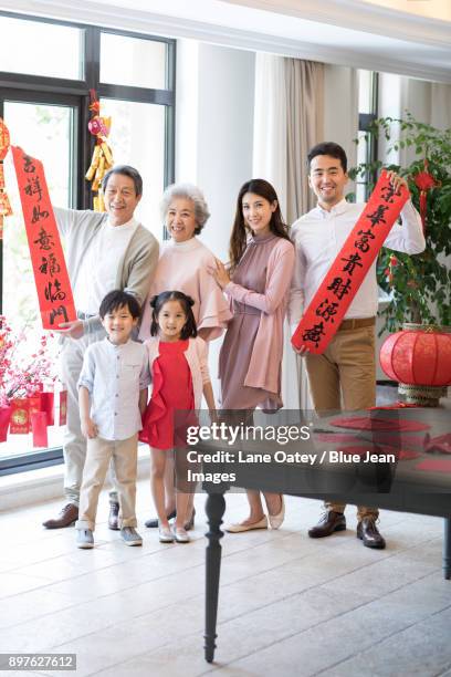 cheerful young family celebrating chinese new year - 30 year old portrait in house stock-fotos und bilder