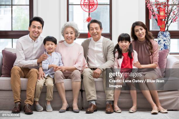 happy family celebrating chinese new year - 30 year old portrait in house stock-fotos und bilder