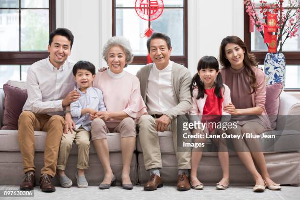 happy family celebrating chinese new year - 30 year old portrait in house stockfoto's en -beelden