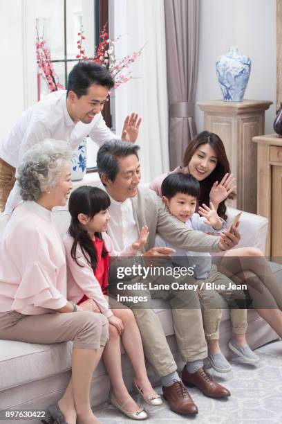 happy family having video chat on smart phone during chinese new year - bainian stock pictures, royalty-free photos & images