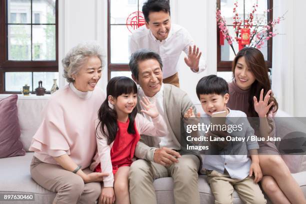 happy family having video chat on smart phone during chinese new year - bainian stock pictures, royalty-free photos & images