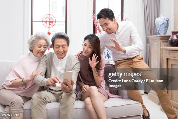 happy family having video chat on smart phone during chinese new year - bainian stock pictures, royalty-free photos & images