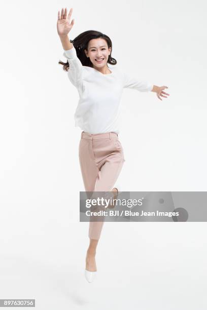 cheerful young businesswoman jumping - runner front view stock pictures, royalty-free photos & images