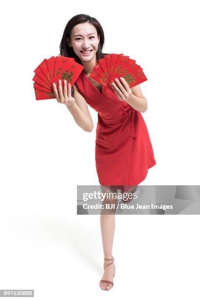 cheerful young woman with red envelops for chinese new year - bainian stock pictures, royalty-free photos & images