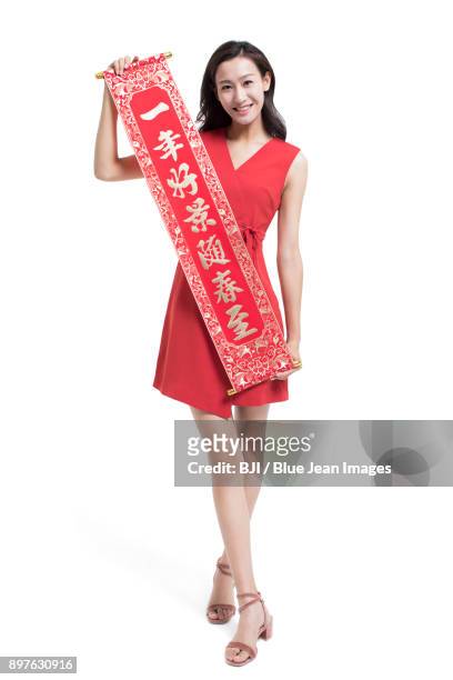 cheerful young woman with couplet celebrating chinese new year - bainian stock pictures, royalty-free photos & images