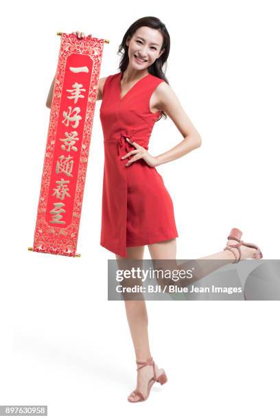 cheerful young woman with couplet celebrating chinese new year - bainian stock pictures, royalty-free photos & images