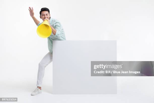 young man shouting through megaphone - good news poster stock pictures, royalty-free photos & images