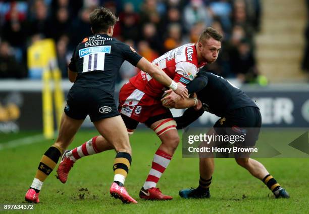 Ruan Ackermann of Gloucester tackled by Joe Simpson and Josh Bassett of Wasps during the Aviva Premiership match between Wasps and Gloucester Rugby...