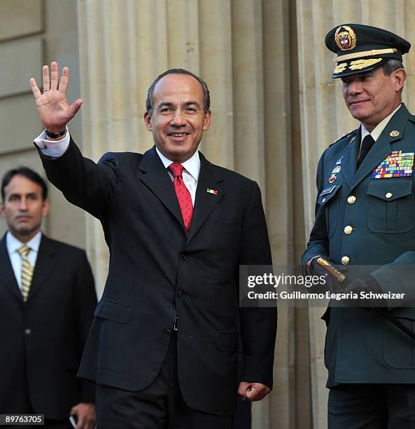 Mexico's President Felipe Calderon waves to photographers during a meeting with Colombia's President Alvaro Uribe and Army Forces chief Freddy...