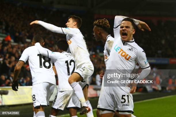 Swansea City's Spanish midfielder Roque Mesa reacts as Swansea City's Ghanaian striker Jordan Ayew celebrates with teammates after scoring their...