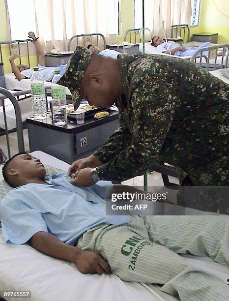 An unidentified wounded Philippine Marine receives a medal from the military regional commander, Major General Benjamin Dolorfino , at a hospital in...