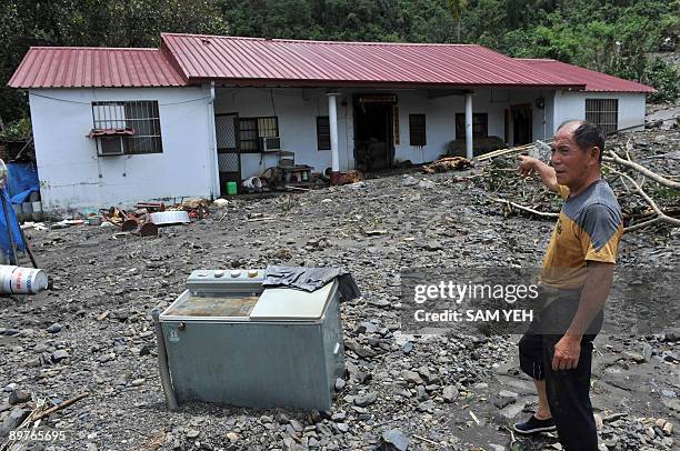 Local resident points at a house damaged by mudslides brought by Typhoon Morakot in Liukuei, in Kaohsiung county, southern Taiwan, on August 13,...