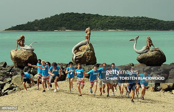 The 16 finalists for the 'Best Job In The World' position as caretaker of Australia's Great Barrier Reef run along the coral beach on Daydream Island...