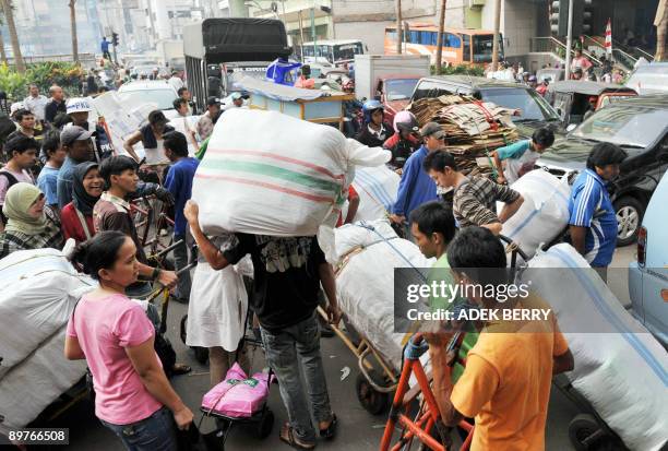 Vehicles wait as passersby crowd a street in Jakarta on August 13, 2009. Indonesia's economy grew at its slowest annual pace in seven years in the...