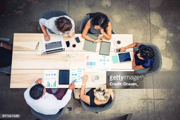 group of financial professionals analyzing markets - overhead view stock pictures, royalty-free photos & images