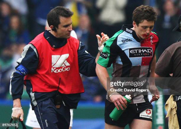 Tom Williams of Harlequins walks off with physio Steph Brennan to be replaced by team mate Nick Evans as blood pours from his mouth during the...